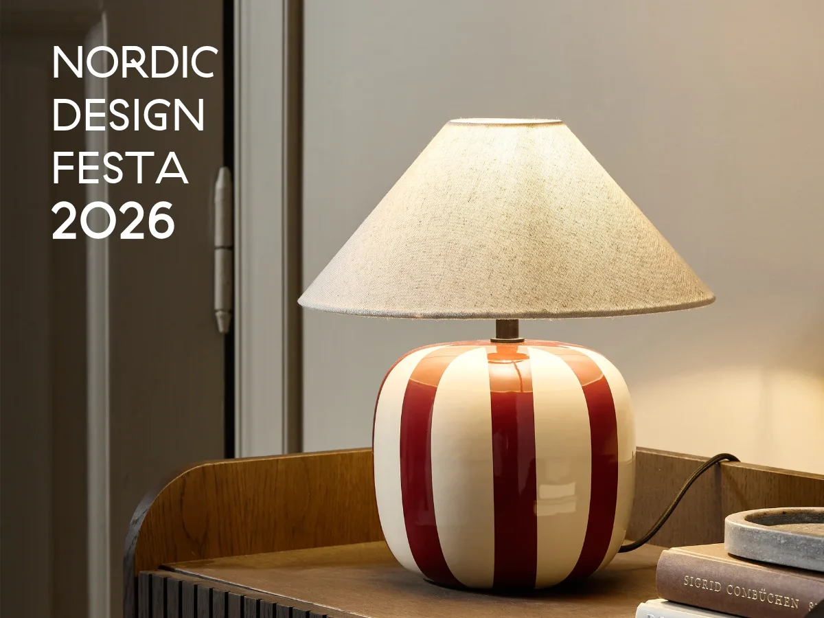 빨간색과 흰색 줄무늬 테이블 램프, 베이지색 패브릭 갓, 나무 협탁 위에 놓여 있음. 텍스트: Nordic Design Festa 2026.