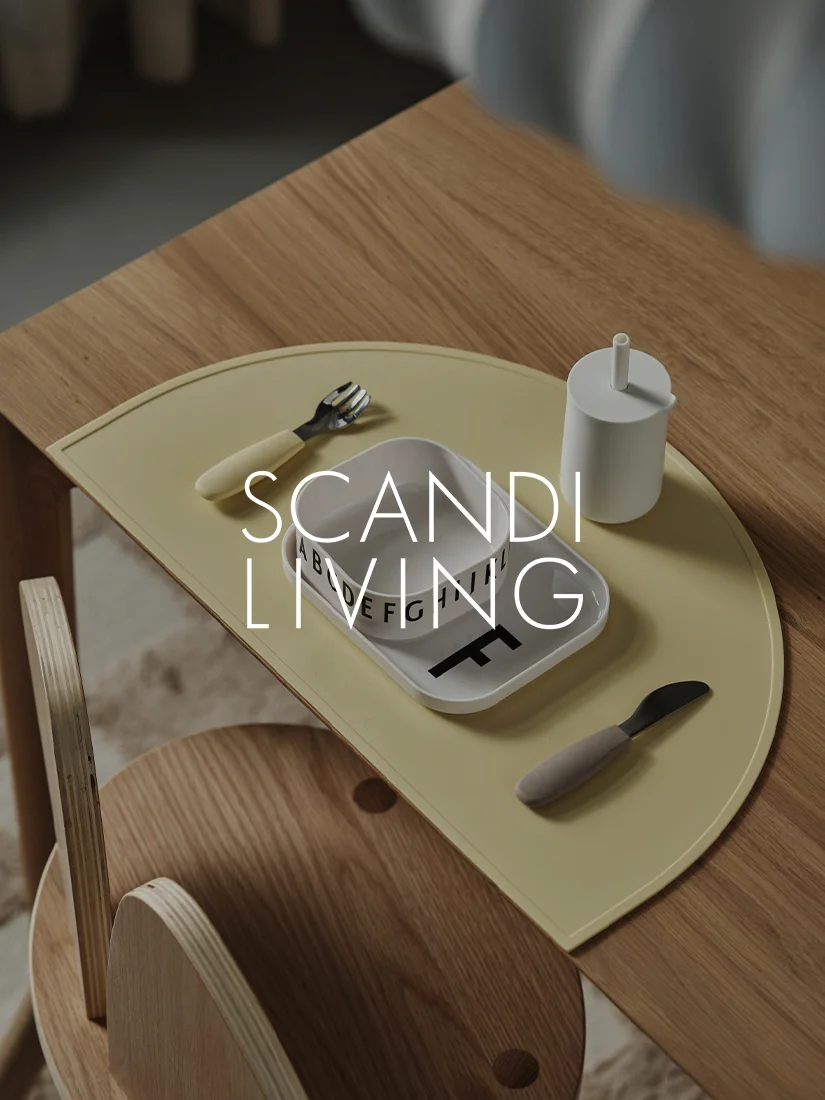 노란색 식탁 매트, 알파벳이 적힌 흰색 접시, 컵, 포크, 나이프가 놓인 나무 어린이용 테이블.