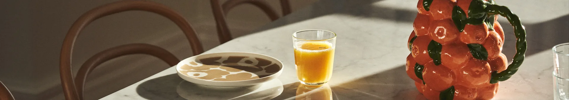 마리메코의 포셀린으로 세팅된 테이블, BYON 디자인의 오렌지 모양 주스와 카라페를 만나보세요.
