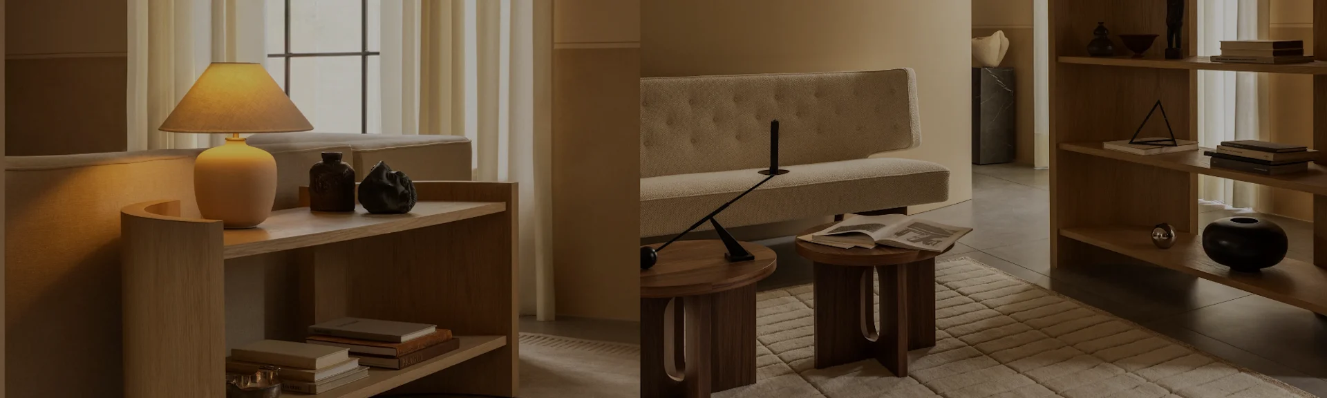 베이지색 소파, 나무 협탁, 장식품과 책이 있는 책장 등 뉴트럴 톤 가구로 따뜻하게 조명된 거실.