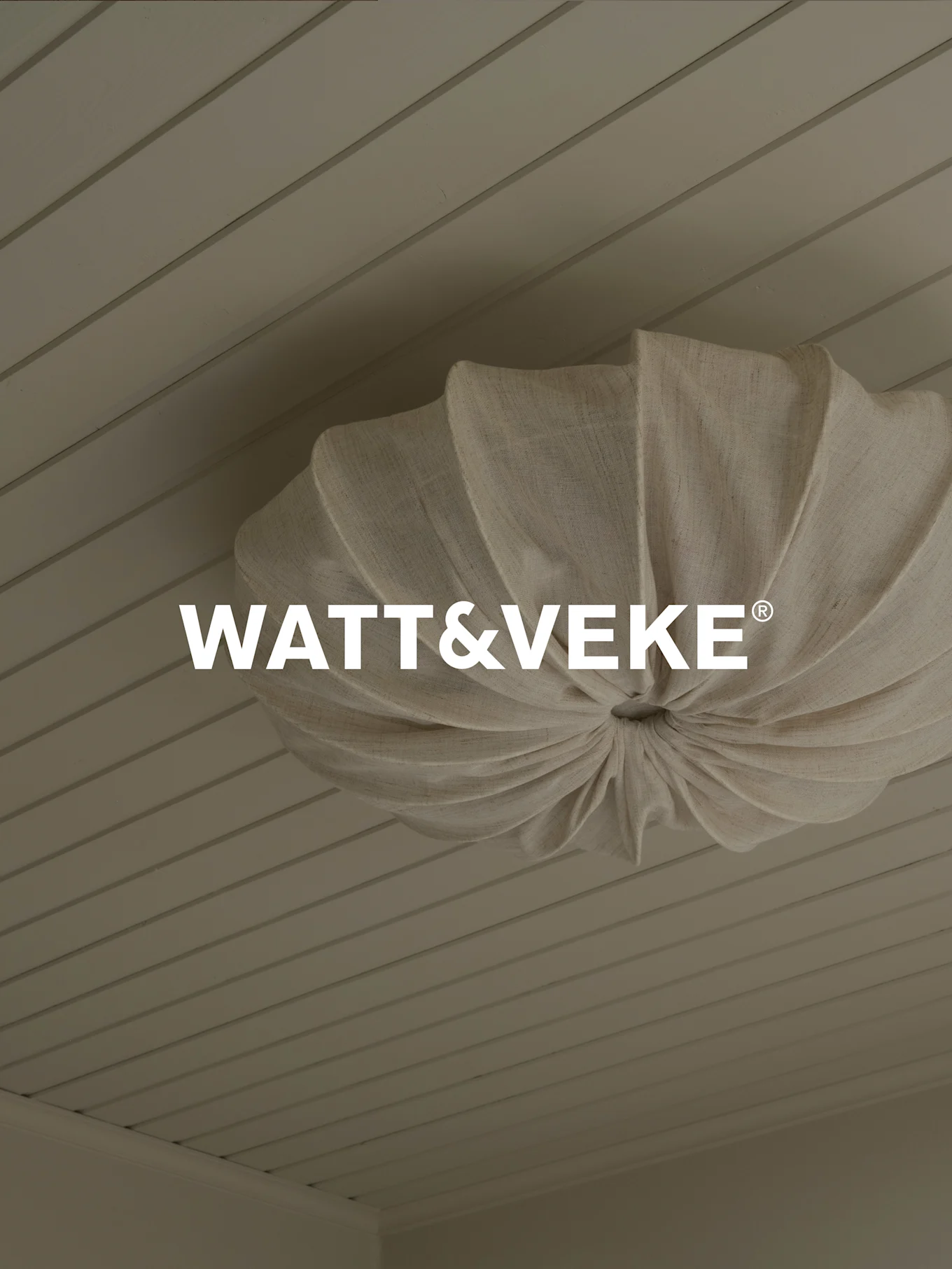 WATT&VEKE® 로고와 밝은 나무 판자 천장에 주름 잡힌 천연 직물 천장 조명.